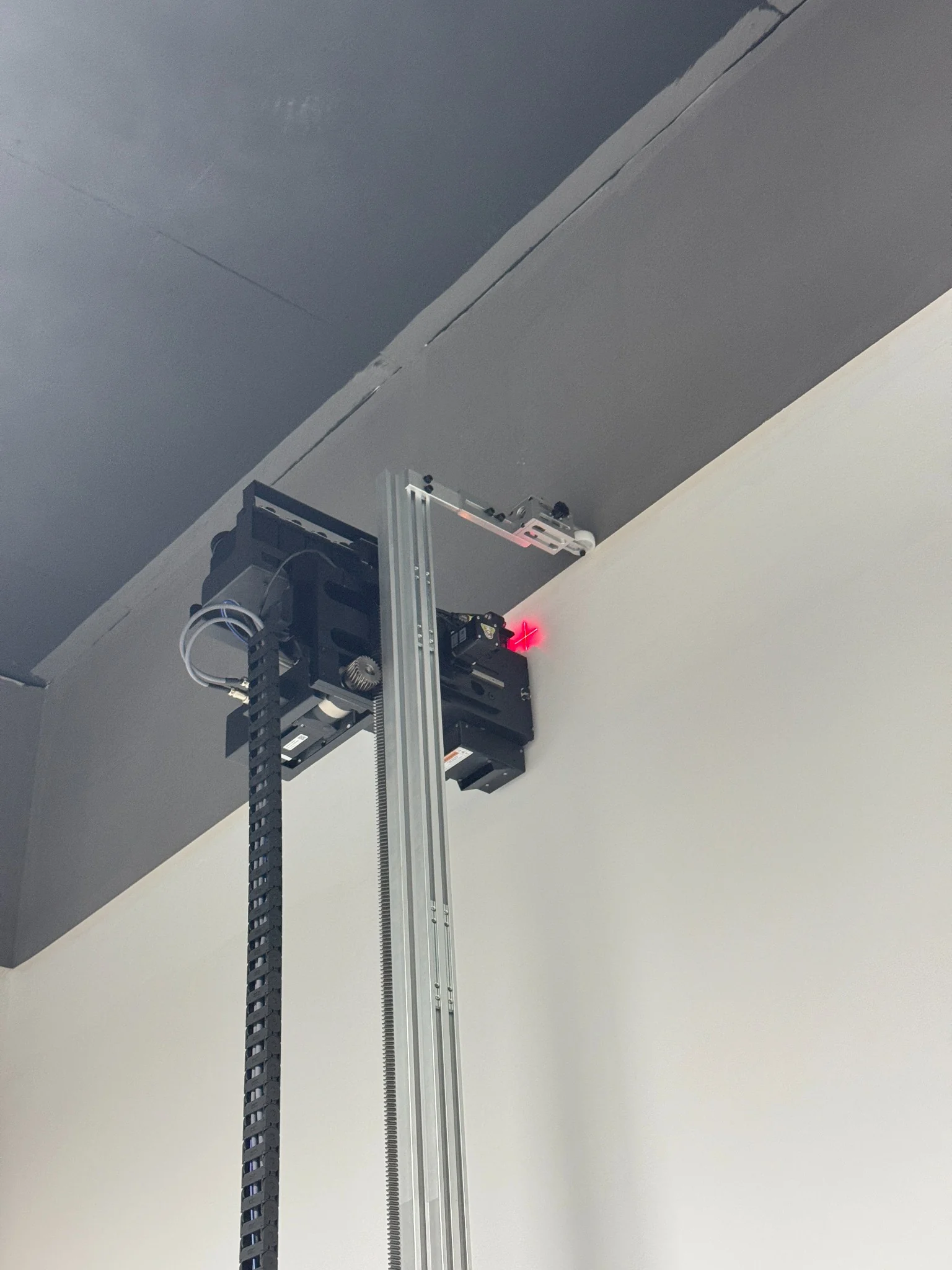StabiArm installed at the top of a DXonJet wall printer during a high position print