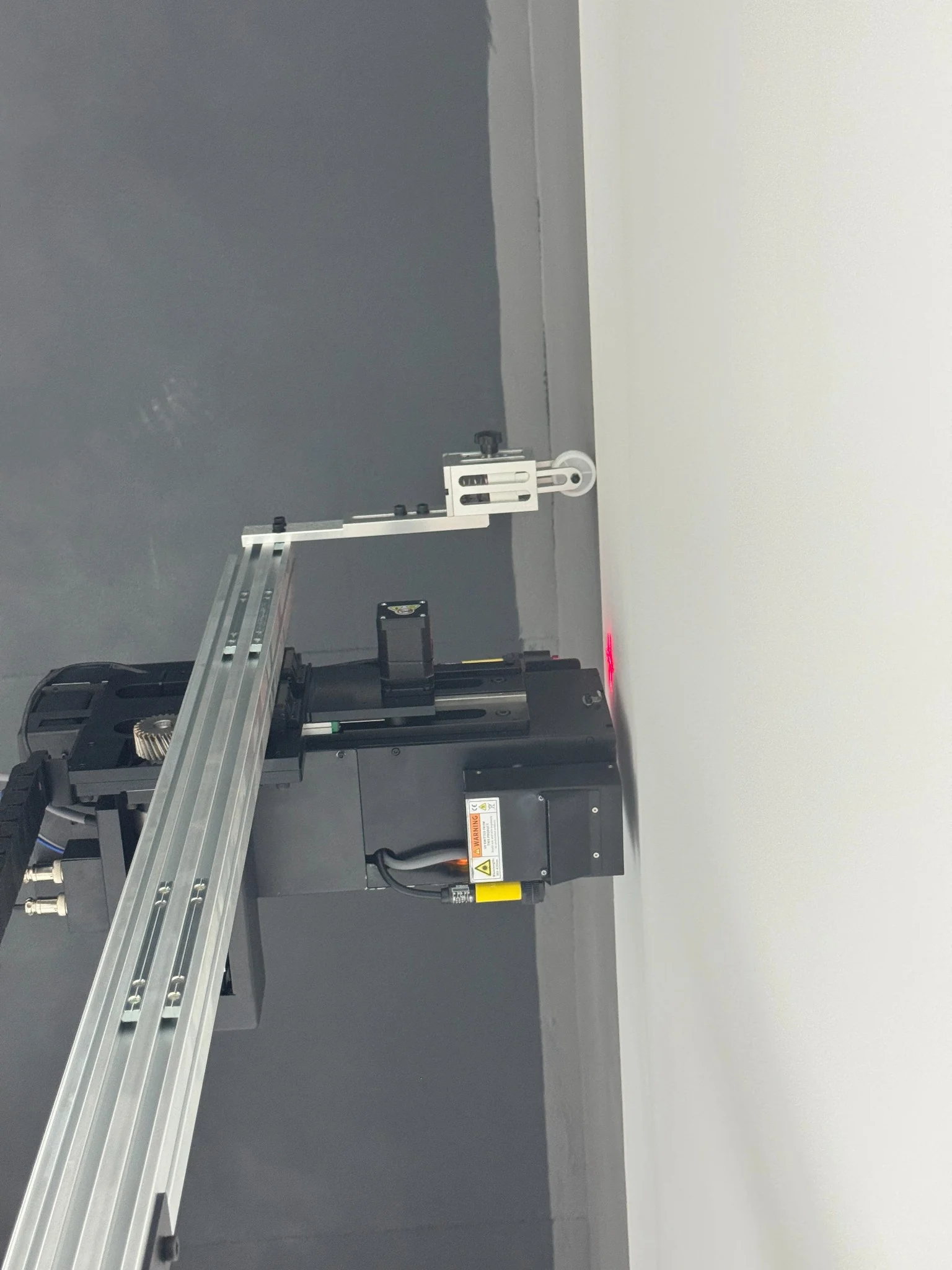 Side view of StabiArm roller contacting the wall above the DXonJet printhead